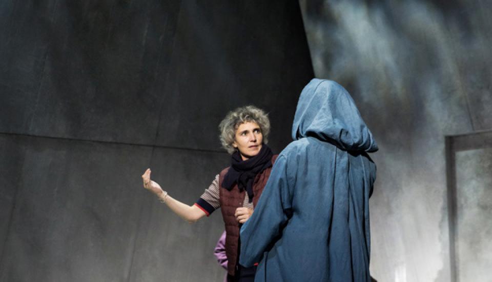 La metteuse en scène Célie Pauthe donne des conseils à une chanteuse vêtue d'une cape bleue.