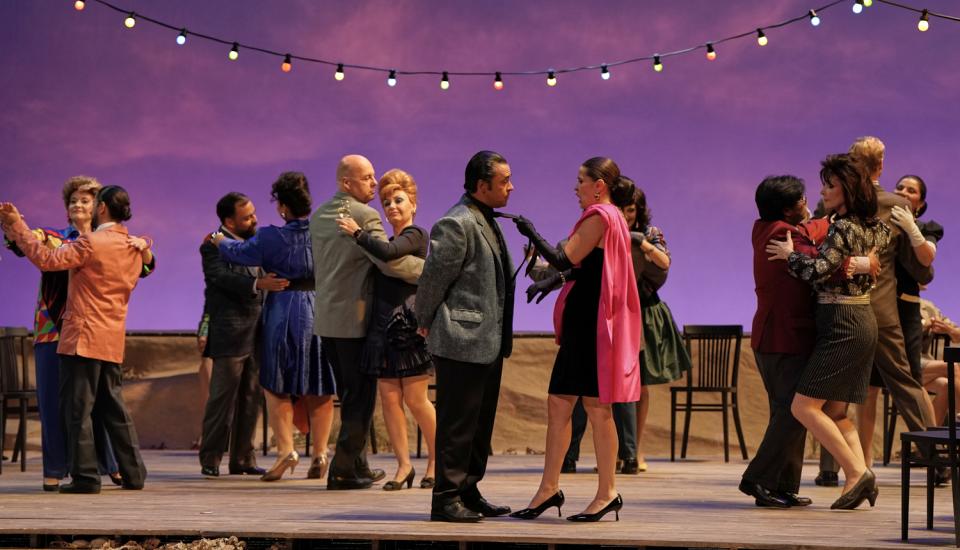 Alors que des couples dansent, un femme tire un homme par la cravate au premier plan